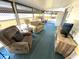 Bright sunroom featuring neutral furniture, large windows, and a blue carpet at 235 Trailorama Dr, North Port, FL 34287