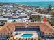 Aerial view showcases the condo building with a pool, close beach access, and a stunning ocean backdrop at 2405 N Beach Rd # 4, Englewood, FL 34223