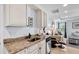 Kitchen with granite counters and white cabinets opens into a living area with tiled floor at 2405 N Beach Rd # 4, Englewood, FL 34223