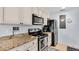 Modern kitchen with granite countertops, stainless steel appliances and sleek white cabinetry at 2405 N Beach Rd # 4, Englewood, FL 34223