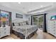 This light and airy main bedroom offers a king bed, dresser with television, and sliding door to a private balcony at 2405 N Beach Rd # 4, Englewood, FL 34223