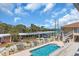 Community pool with lounge chairs, covered parking, fenced in area, and views of the water at 2405 N Beach Rd # 4, Englewood, FL 34223