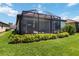 Manicured backyard with screened patio and lush landscaping, creating a private oasis at 24153 Spartina Dr, Venice, FL 34293