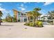 Modern Banyan House with expansive windows and tropical landscaping, creating a welcoming atmosphere at 24153 Spartina Dr, Venice, FL 34293