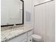 Well-lit bathroom showcasing granite counters, framed mirror, and white shower curtain at 24153 Spartina Dr, Venice, FL 34293