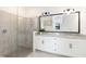 Modern bathroom with a glass-enclosed shower and a double vanity with granite countertops at 24153 Spartina Dr, Venice, FL 34293