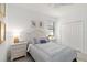 Bright bedroom features a full-size bed, closet, and a pair of matching nightstands at 24153 Spartina Dr, Venice, FL 34293