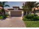 Charming one-story home with a brick driveway, beautiful landscaping, and a neutral color palette at 24153 Spartina Dr, Venice, FL 34293
