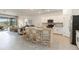 Open kitchen with an island bar, white cabinets, and seamless access to the patio at 24153 Spartina Dr, Venice, FL 34293