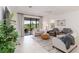 Sun-drenched living room features light gray tile floors, neutral color palette, and backyard views at 24153 Spartina Dr, Venice, FL 34293