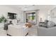 Living room boasts a large sliding glass door, light gray tile floors, and a neutral color palette at 24153 Spartina Dr, Venice, FL 34293