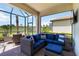Relax on this screened-in patio with wicker furniture and views of the green backyard at 24153 Spartina Dr, Venice, FL 34293