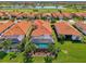 Aerial view of tile-roofed homes overlooking a golf course and lake, showcasing the community's serene setting at 24193 Gallberry Dr, Venice, FL 34293