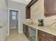 Wet bar with undercounter beverage refrigerator, granite counters, and direct access to the bathroom at 24193 Gallberry Dr, Venice, FL 34293