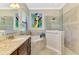 Well-lit bathroom featuring a soaking tub, glass-enclosed shower, granite countertop and sleek fixtures at 24193 Gallberry Dr, Venice, FL 34293