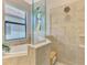 Bathroom showcasing a glass-enclosed shower, a separate tub, and natural light from a nearby window at 24193 Gallberry Dr, Venice, FL 34293