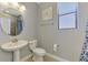 Bright, half bathroom with stylish fixtures, decor, and round mirror at 24193 Gallberry Dr, Venice, FL 34293