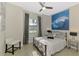 Comfortable bedroom features a ceiling fan, large window, and a decorative painting above the bed at 24193 Gallberry Dr, Venice, FL 34293