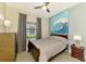 Cozy bedroom with a ceiling fan, a full-size bed, natural lighting, and patterned curtains at 24193 Gallberry Dr, Venice, FL 34293
