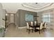 Open-concept dining area featuring designer ceilings, tile floors, and stylish decor with backyard views at 24193 Gallberry Dr, Venice, FL 34293