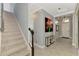 Spacious foyer features a staircase, decorative artwork, and stylish light fixtures at 24193 Gallberry Dr, Venice, FL 34293
