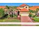 Charming home features a red tile roof, two car garage, manicured landscaping and brick paved driveway at 24193 Gallberry Dr, Venice, FL 34293