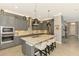 Elegant kitchen with stainless steel appliances, eat-in island, and gray cabinets at 24193 Gallberry Dr, Venice, FL 34293