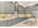 Close-up of gourmet kitchen featuring gray cabinetry, modern range hood, and updated countertops at 24193 Gallberry Dr, Venice, FL 34293