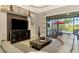 Bright living room featuring a modern entertainment center and sliding glass doors leading to the pool at 24193 Gallberry Dr, Venice, FL 34293