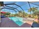Screened pool and spa overlook the lush, tropical landscape, ideal for outdoor relaxation and entertainment at 24193 Gallberry Dr, Venice, FL 34293