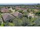 An aerial view showcases a landscaped property with a screened-in lanai, near trees and other homes at 2542 Cortenova Ct, Venice, FL 34292