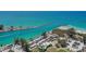 Aerial view of Venice Beach highlighting turquoise waterways, a pier, and a large parking area for visitors at 2542 Cortenova Ct, Venice, FL 34292