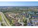 A wide aerial shot shows homes within a community of ponds, greenery, and a nearby highway at 2542 Cortenova Ct, Venice, FL 34292
