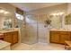 Bright bathroom with double vanity, tile floors, and walk-in glass shower at 2542 Cortenova Ct, Venice, FL 34292