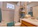 Well-lit bathroom with a shower-tub combo, neutral tiles, and decorative nautical accents at 2542 Cortenova Ct, Venice, FL 34292