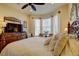 Comfortable bedroom with large windows, a television, and a classic wrought iron bed frame at 2542 Cortenova Ct, Venice, FL 34292