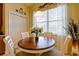Cozy breakfast nook featuring a round wood table, seating for four, and a bright window with sheer curtains at 2542 Cortenova Ct, Venice, FL 34292