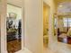 Hallway showcasing access to a closet, bathroom, and bedroom with tray ceiling at 2542 Cortenova Ct, Venice, FL 34292
