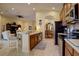 Bright, open kitchen with stainless steel appliances, tile flooring, breakfast bar, and seamless access to the living and dining areas at 2542 Cortenova Ct, Venice, FL 34292