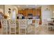 Charming kitchen featuring stainless steel appliances, wooden cabinetry, and a breakfast bar with elegant seating at 2542 Cortenova Ct, Venice, FL 34292