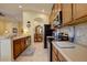 Well-lit kitchen boasting stainless steel appliances, ample counter space, tile backsplash, and seamless flow into the dining area at 2542 Cortenova Ct, Venice, FL 34292