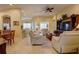 Open-concept living room featuring cozy seating, ceiling fan, and seamless flow into the dining area at 2542 Cortenova Ct, Venice, FL 34292