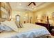 Comfortable bedroom with tray ceilings, soft lighting, and views into the ensuite bathroom at 2542 Cortenova Ct, Venice, FL 34292