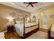 Warm and inviting main bedroom featuring tray ceilings, wood floors, and ensuite bath at 2542 Cortenova Ct, Venice, FL 34292