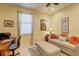 Comfortable home office with a sofa, desk, and neutral decor at 2542 Cortenova Ct, Venice, FL 34292