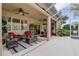 Inviting screened patio with comfortable wicker furniture, ceiling fans, and views of the lush backyard at 2542 Cortenova Ct, Venice, FL 34292