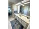 Bathroom featuring a white vanity with a large mirror and a doorway to the bedroom at 262 Mariner Dr, North Port, FL 34287