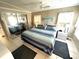 Bright bedroom featuring tile flooring, ceiling fan, and comfortable blue bedding with a mirrored closet at 262 Mariner Dr, North Port, FL 34287