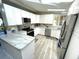 Bright kitchen with modern appliances, white cabinets, and light countertops and floors at 262 Mariner Dr, North Port, FL 34287