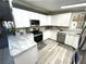 Modern kitchen features white cabinets, light countertops, stainless steel appliances, and great lighting at 262 Mariner Dr, North Port, FL 34287